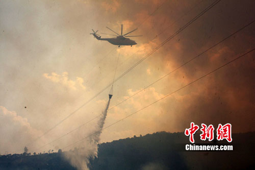 A helicopter fights the fire which broke out Tuesday in a forest in Baoshan City, southwest China's Yunnan Province, March 8, 2011. [Photo: Chinanews.com] 