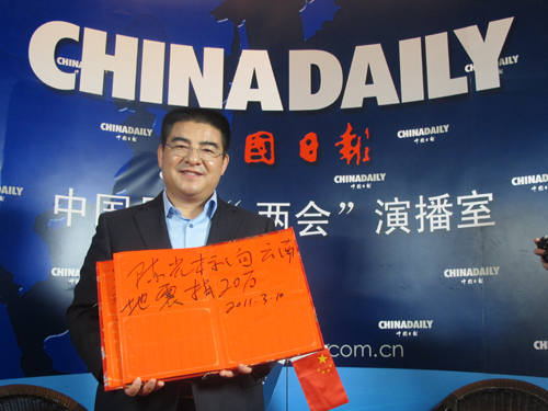 China's top philanthropist Chen Guangbiao poses with the words 'Chen Guangbiao donates 200,000 yuan to Yunnan earthquake victims' Thursday in Beijing. [Photo/chinadaily.com.cn]    