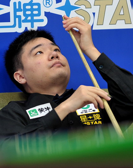 Ding Junhui checks his cue during his Hainan Classic game against compatriot Yu Delu yesterday.  