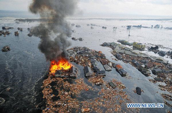 Houses and buildings are seen washed away by massive tsunami waves after a powerful quake in a photo taken from a Kyodo News helicopter in Natori, Miyagi Prefecture, northeastern Japan, on March 11, 2011. An earthquake measuring 8.8 on the Richter scale jolted off the east coast of Japan's main Honshu island Friday. [Xinhua]