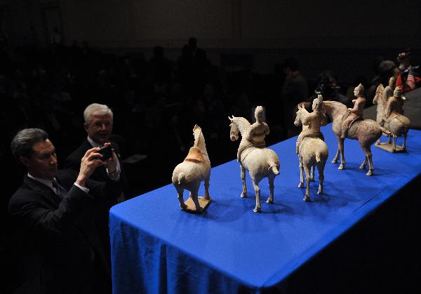 Guests watch ancient Chinese pottery horse sculptures during an ancient Chinese artifacts returning ceremony in Washington D.C., capital of the United States, March 11, 2011.