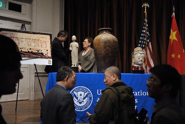 Guests watch ancient Chinese artifacts returning to China during an ancient Chinese artifacts returning ceremony in Washington D.C., capital of the United States, March 11, 2011. 