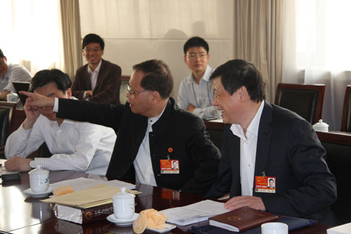 Gong Xueping (front, central), member of the National People's Congress (NPC) Standing Committee, reacts during NPC deputies' panel discussion on work report of NPC Standing Committee in Beijing, on Friday, March 11, 2011. 
