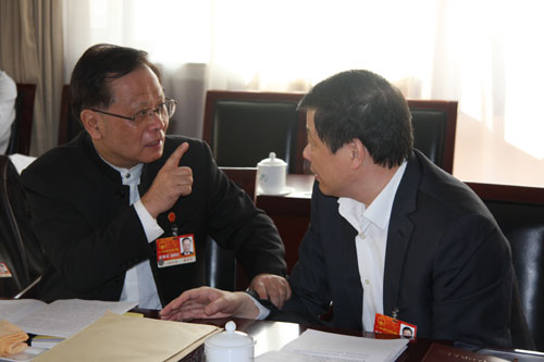 Gong Xueping (left), member of the National People's Congress (NPC) Standing Committee, discusses with Ying Yong, head of Shanghai Higher People's Court, during NPC deputies' panel discussion on work report of NPC Standing Committee in Beijing, on Friday, March 11, 2011.