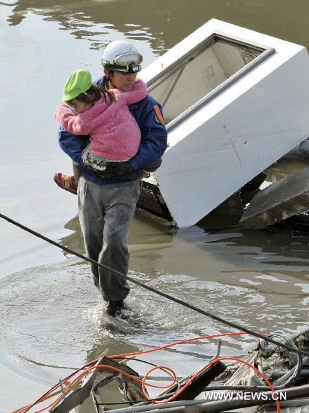 A girl is rescued in Kesennuma city in Miyagi prefecture, Japan, March 12, 2011. At least 630 people were killed after Friday's great earthquake and ensuing huge tsunami hit northeast Japan, public broadcaster NHK reported Saturday.