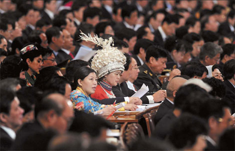 Showing the culture: Two ethnic minority members of Chinese People's Political Consultative Conference (CPPCC) National Committee are seen in the packed meeting room. 