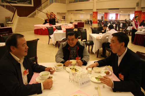 NPC deputy Chu Junhao (1st, left) talks with other deputies about the work report of the NPC Standing Committee while they have breakfast at the Jingxi hotel in Beijing on Friday, March 11, 2011. Besides official panel discussions, Chu Junhao would like to discuss work reports and deputies' motions at other times during the NPC's annual session.
