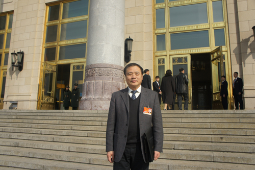NPC deputy Chu Junhao poses in front of the Great Hall of the People before he attends the NPC deputies' third plenary meeting in Beijing on Friday, March 11, 2011. China's top judge and top procurator delivered work reports at the third plenary meeting of the annual parliament session Friday afternoon. 