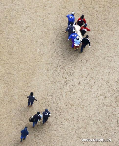 Rescuers transport a victim in Miyako, Iwate Prefecture, Japan, March 12, 2011. Over 1,000 people has been killed after Friday's great earthquake and ensuing huge tsunami hit northeast Japan, public broadcaster NHK reported Saturday. [Xinhua]