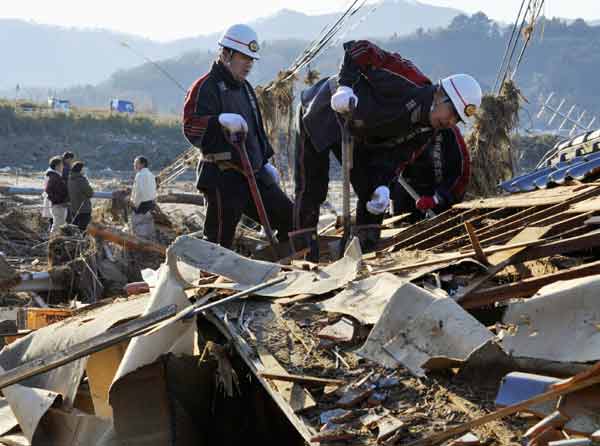 Rescue workers look for missing people in houses destroyed by a tsunami in Yamamoto, Miyagi Prefecture in northeastern Japan March 12, 2011. Japan confronted devastation along its northeastern coast on Saturday, with fires raging and parts of some cities under water after a massive earthquake and tsunami that likely killed at least 1,000 people. [Xinhua]