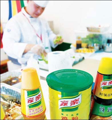 A chef makes meals at a fast food restaurant in Shanghai. In front of him are compound condiments made by Unilever. Unilever and Nestle possess the lion's share of the market for such products in China. [China Daily]
