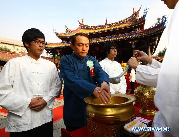 An attendee washes his hands during a ceremony worshipping Confucius in Taipei, southeast China's Taiwan, March 13, 2011. Confucius (551 B.C. -- 479 B.C.), native of Qufu in east China's Shandong Province, was a great thinker, philosopher, and educator in ancient China.