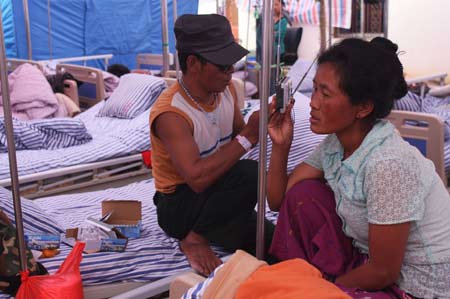 A survivor of the Yingjiang earthquake listens to the radio to learn about rescue efforts. 