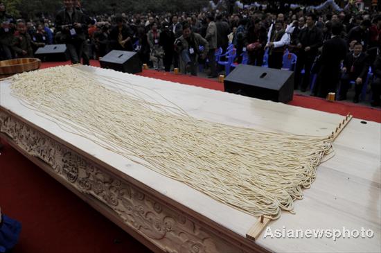 A 1,704-meter-long (1.06 mile) stretch of noodle is displayed during a noodle-making activity at a square in Weishan county of Dali Bai autonomous prefecture in Southwest China's Yunnan province, March 12, 2011. 