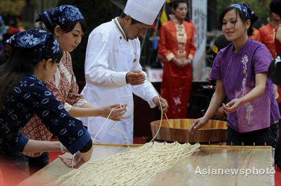 A chef surnamed Su makes the world's longest stretched noodle with his assistants, March 12, 2011. 
