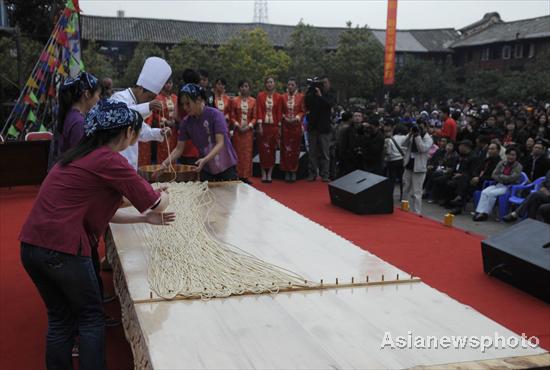 A chef surnamed Su makes the world's longest stretched noodle with his assistants, March 12, 2011. 