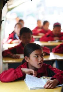 Students of Gangmeng Center Primary School have a lesson inside a tent classroom in Pingyuan Township of quake-hit Yingjiang County, southwest China's Yunnan Province, March 14, 2011. 