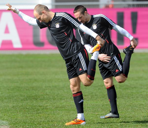 Bayern Munich's French midfielder Franck Ribery (R) and Dutch midfielder Arjen Robben stretch during a training session in Munich, southern Germany, Monday , March 14, 2011. (Xinhua/AFP Photo)