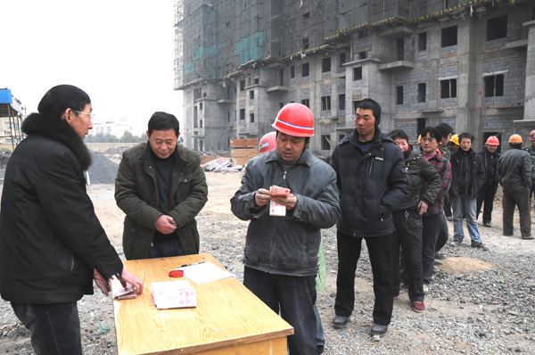 Workers could put a little more pay in their pockets if proposals to reduce individual income tax are adopted. The tax starting point is expected to rise from 2,000 yuan a month in wages to at least 3,000. These migrant workers were collecting their pay at a construction site in Jiyuan, Henan province.