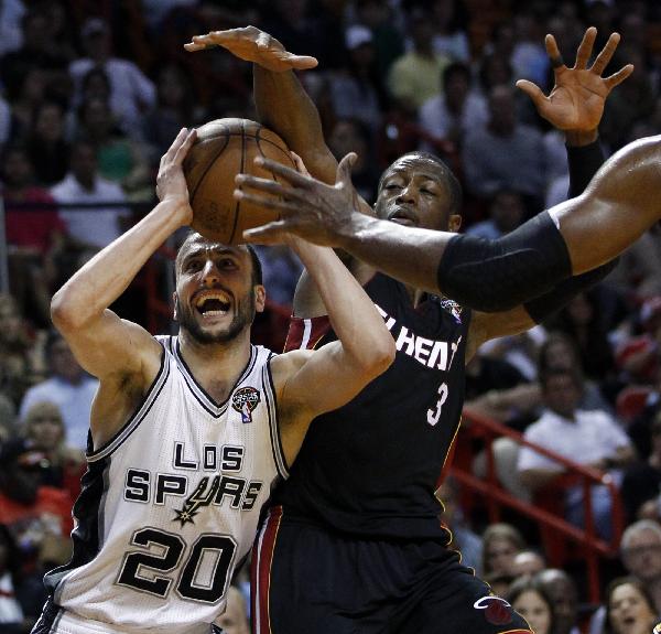 San Antonio Spurs Manu Ginobili (L) looks to shoot over the defense of the Miami Heat's Dwyane Wade during second quarter NBA basketball action in Miami, Florida March 14, 2011.(Xinhua/Reuters Photo) 