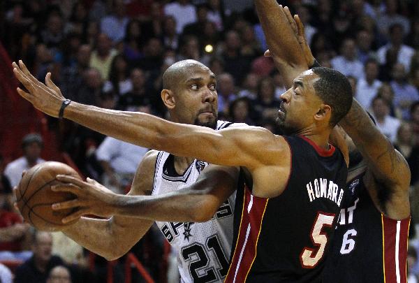 San Antonio Spurs Tim Duncan (L) is contained by the defense of Miami Heat's Juwan Howard during second quarter NBA basketball action in Miami, Florida March 14, 2011.(Xinhua/Reuters Photo) 