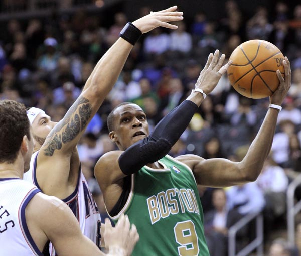 Boston Celtics guard Rajon Rondo (R) tries to make a layup as he drives past New Jersey Nets guard Deron Williams in the first quarter of their NBA basketball game in Newark, New Jersey March 14, 2011.(Xinhua/Reuters Photo) 