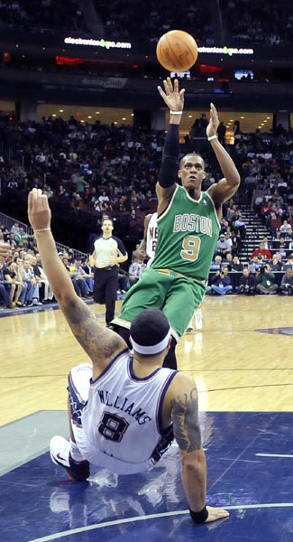 Boston Celtics guard Rajon Rondo (9) drives into New Jersey Nets guard Deron Williams (8) as he shoots in the first quarter of their NBA basketball game in Newark, New Jersey, March 14, 2011.(Xinhua/Reuters Photo) 