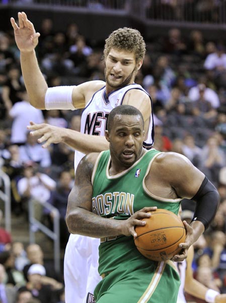 Boston Celtics forward Glen Davis (front) grabs a rebound in front of New Jersey Nets center Brook Lopez in the second quarter of their NBA basketball game in Newark, New Jersey March 14, 2011.(Xinhua/Reuters Photo) 