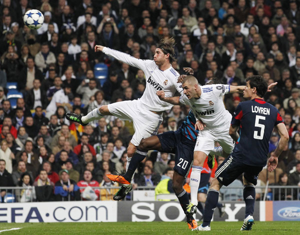 Real Madrid's Karim Benzema (2nd R) heads the ball into Olympique Lyon's goal past Olympique Lyon's Dejan Lovren (R), Olympique Lyon's Aly Cissokho (C) and Real Madrid's Sergio Ramos during their second leg round of 16 Champions League soccer match at Santiago Bernabeu stadium in Madrid March 16, 2011. The goal was disallowed. (Xinhua/Reuters Photo) 