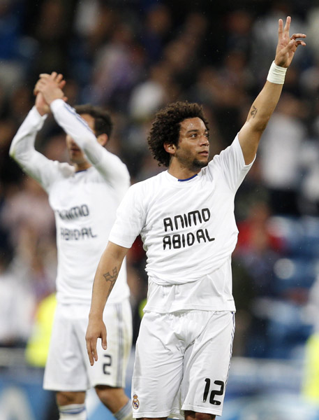 Real Madrid's Marcelo (R) and Ricardo Carvalho acknowledge supporters as they wear shirts giving courage to Barcelona's player Adibal, who is to undergo surgery, at the end of their second leg round of 16 Champions League soccer match against Olympique Lyon at Santiago Bernabeu stadium in Madrid March 16, 2011. (Xinhua/Reuters Photo) 