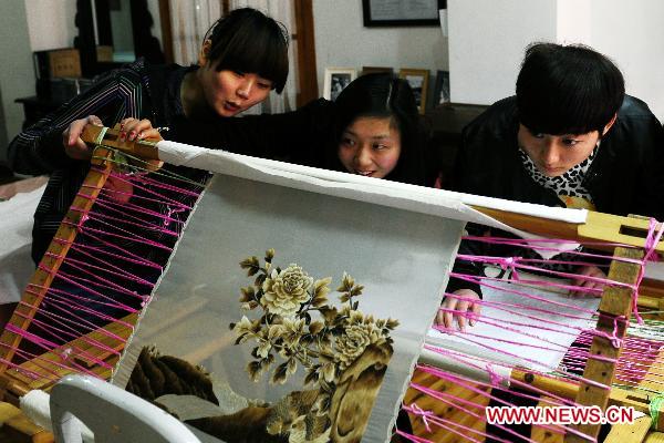 Students view a Sichuan embroidery artwork sewn with hairs at the Sichuan needlework museum in Chengdu, capital of southwest China's Sichuan Province, March 16, 2011. 