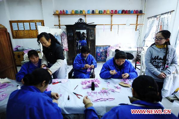 Craftswomen make artworks at the Sichuan needlework museum in Chengdu, capital of southwest China's Sichuan Province, March 16, 2011.