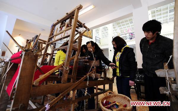 Students view some spinning machines at the Sichuan needlework museum in Chengdu, capital of southwest China's Sichuan Province, March 16, 2011. 
