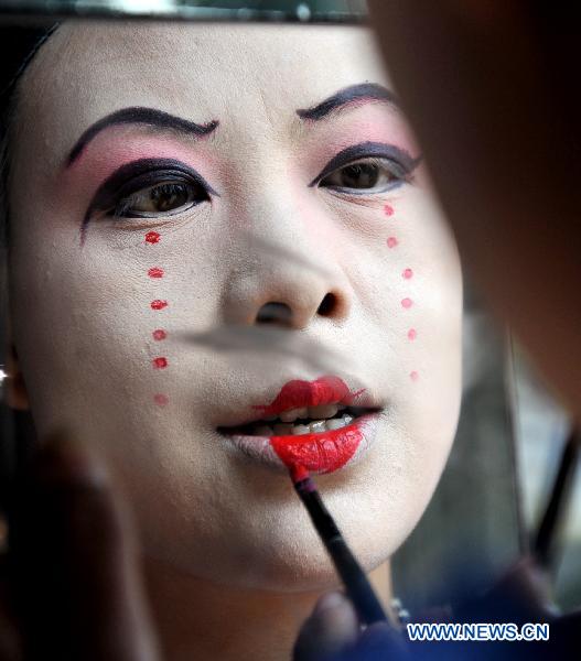 An actress of a local troupe makes up before the Mulian Opera performance in Xinchang County, east China's Zhejiang Province, March 14, 2011