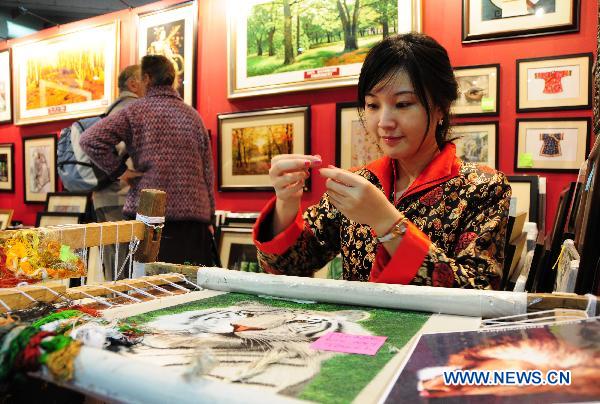 A girl demonstrates the traditional Chinese Suzhou Embroidery at the Ideal Home Show held at Earls Court Exhibition Centre in London, Britain, March 16, 2011. 