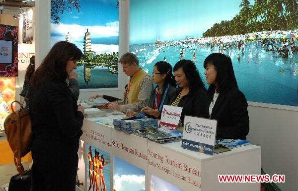 Visitors consulte at the exhibition area of Chinese tourism during the 18th international tourism exhibition in Moscow, Russia, March 16, 2011. The four-day tourism exhibition kicked off in Moscow on Wednesday.