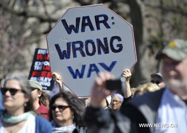 A protestor holds a placard during an anti-war rally to commemorate the 8th anniversary of the Iraq War outside the White House in Washington D.C., capital of the United States, March 19, 2011. (Xinhua/Zhang Jun) (zw) 