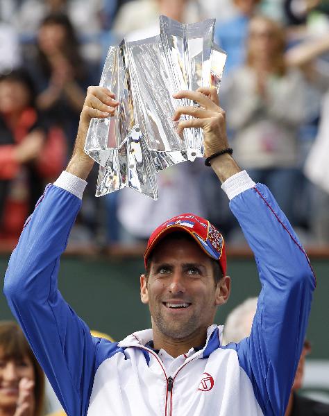 Novak Djokovic of Serbia holds up his trophy after defeating Rafael Nadal of Spain following the men's final of the Indian Wells ATP tennis tournament in Indian Wells, California March 20, 2011. (Photo: Xinhua/Reuters) 
