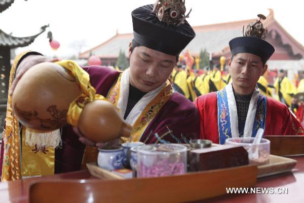 A Taoist priest fills the cup with liquor during a memorial ceremony for Laozi (or Lao-tzu, Lao-tse 604-531 BC) 2,582 birth anniversary in Tianjing Palace (or Heavenly Peace Palace), Woyang County of east China's Anhui Province, March 19, 2011. 