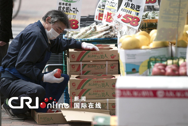 A worker checks vegetables in a supermarket in Tokyo on March 20. 