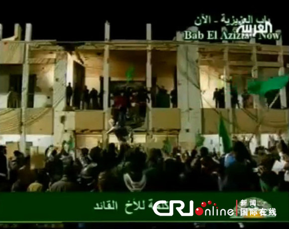 The TV footage showed Gadhafi is making a short live address to his supporters late Tuesday in a week at a balcony near the Libyan capital of Tripolibefore a crowd of supporters at his residence compound. 