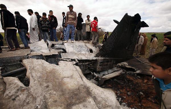 People look at a U.S Air Force F-15E fighter jet after it crashed near the eastern city of Benghazi March 22, 2011. The fighter jet crashed in Libya overnight after apparent mechanical failure but its crew were safe, a spokesman for the U.S. military Africa Command said on Tuesday. [Xinhua]