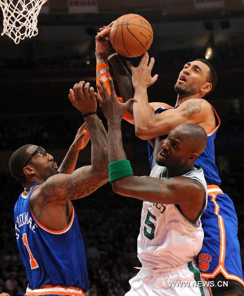 Amar'e Stoudemire(L) and Jared Jeffries(top) of New York Knicks fight for the rebound ball with Kevin Garnett of Boston Celtics during their NBA game in New York, the United States, March 21, 2011. Boston Celtics defeated New York Knicks 96-86. (Xinhua/Shen Hong) 