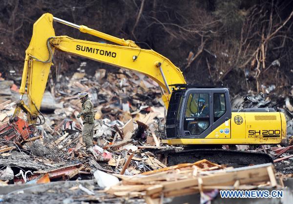 An excavator works on debris in Otsuchi of Iwate Prefecture, Japan, March 21, 2011. Otsuchi is one of the worst devastated area in the earthquake and tsunami.