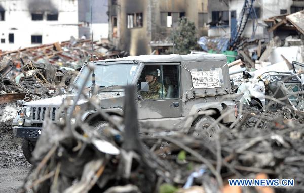 Vehicle of Japanese Self-Defence Force runs among debris in Otsuchi of Iwate Prefecture, Japan, March 21, 2011. Otsuchi is one of the worst devastated area in the earthquake and tsunami. 