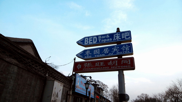 The road signs indicate that hutongs have been through a modern transformation as its residents remodel homes into family inns and wine bars to attract visitors. [Photo:CRIENGLISH.com] 