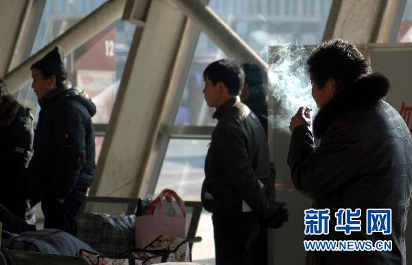 A man smokes in a bus station in Beijing on January 6, 2011. China enacted a new rule to ban smoking in enclosed public locations, according to the country's Ministry of Health on March 22, 2011. 