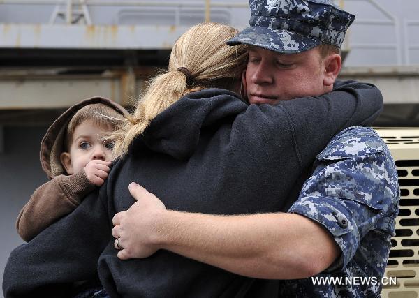 A soldier of the amphibious assault ship USS Bataan (LHD 5) hugs his family before departing from the Norfolk Naval Base in Virginia, the United States, March 23, 2011. The U.S. Navy on Wednesday dispatched the amphibious assault ship USS Bataan, the amphibious transport dock ship USS Mesa Verde and the dock landing ship USS Whidbey Island to the Mediterranean to join the military mission in Libya. [Zhang Jun/Xinhua]