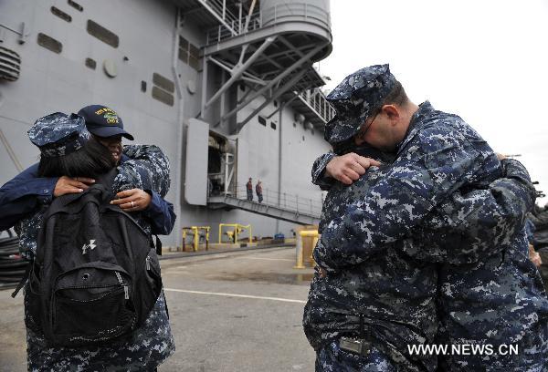 Soldiers of the amphibious assault ship USS Bataan (LHD 5) hug friends before departing from the Norfolk Naval Base in Virginia, the United States, March 23, 2011. The U.S. Navy on Wednesday dispatched the amphibious assault ship USS Bataan, the amphibious transport dock ship USS Mesa Verde and the dock landing ship USS Whidbey Island to the Mediterranean to join the military mission in Libya.[Zhang Jun/Xinhua] 