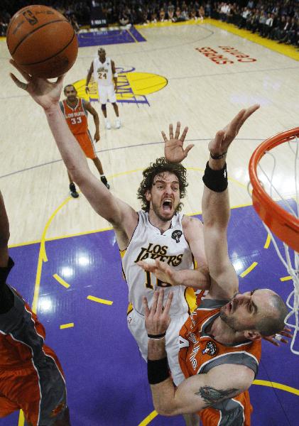 Los Angeles Lakers' Pau Gasol of Spain (L) goes up to shoot past Phoenix Suns' Marcin Gortat of Poland during their NBA game in Los Angeles, California March 22, 2011. Lakers won 139-137. (Xinhua/Reuters Photo)